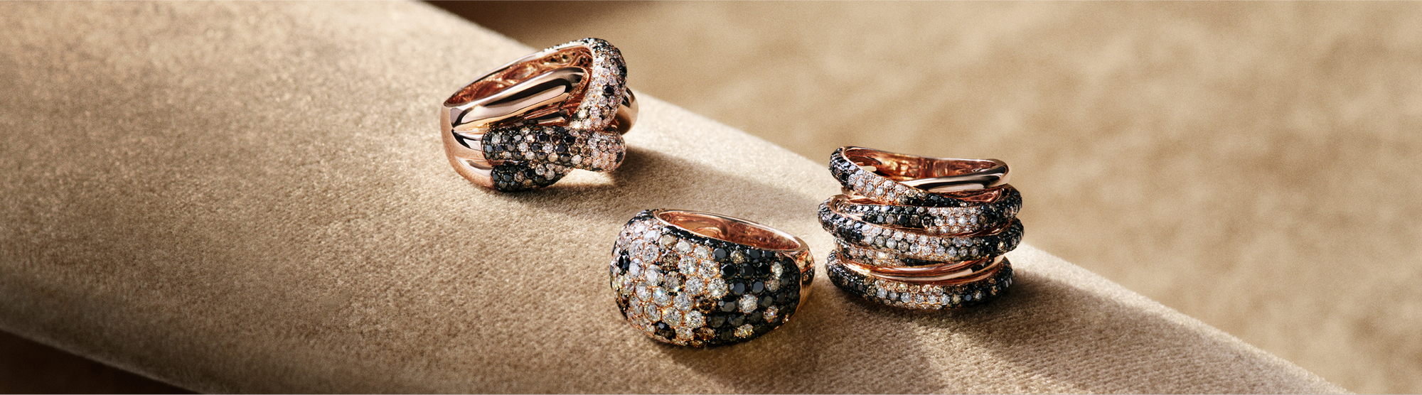 Three gold rings with crisscross patterns of brown and white diamonds are displayed vertically on a gradient green background, next to the text Espresso Diamonds.